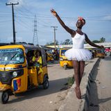 Eine Ballettschülerin in weißem Tutu posiert am Straßenrand vor einem gelben Tuktuk.