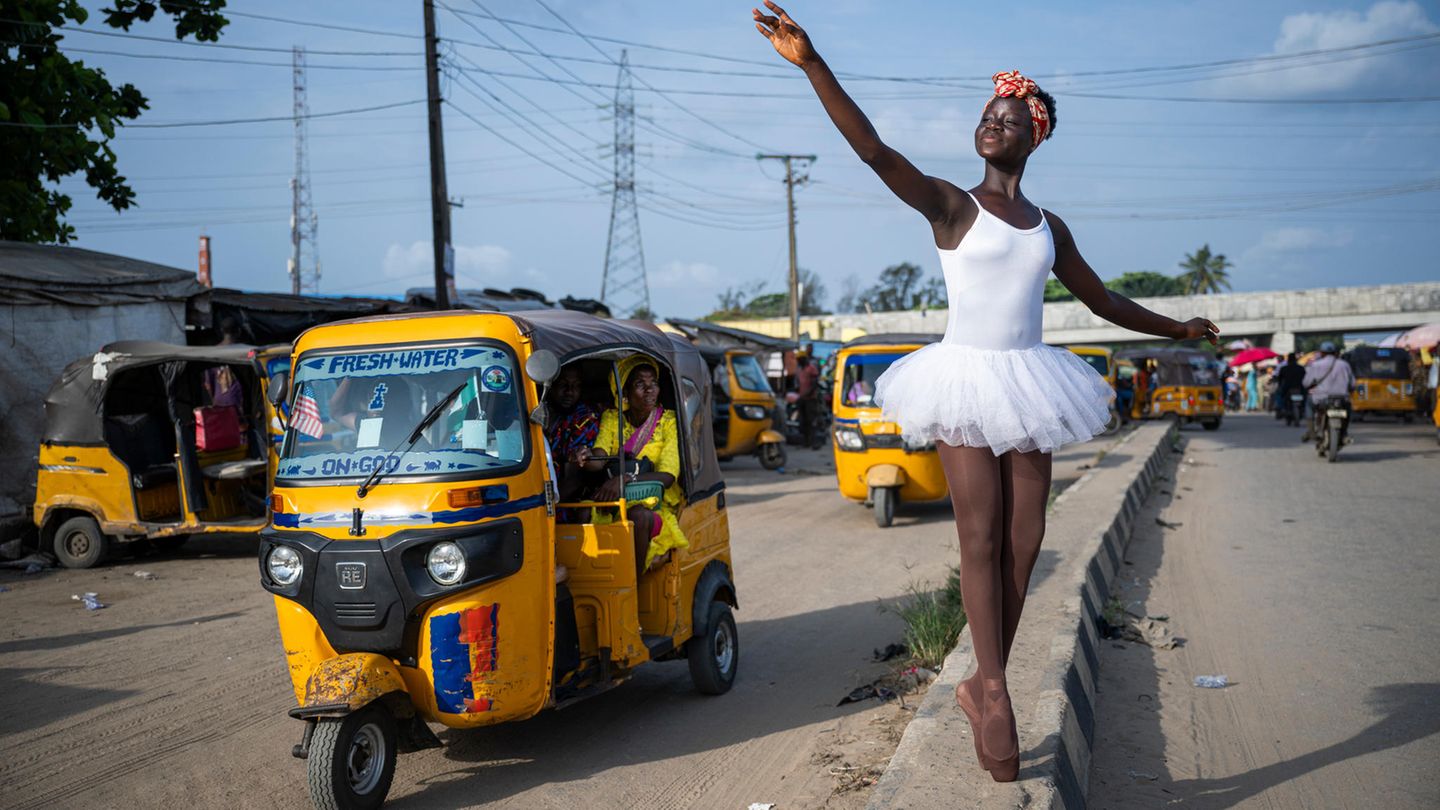 Eine Ballettschülerin in weißem Tutu posiert am Straßenrand vor einem gelben Tuktuk. Eine Ballettschülerin in weißem Tutu posiert am Straßenrand vor einem gelben Tuktuk.