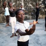 Ein junge in hellem T-Shirt hält seine Arme in Pose