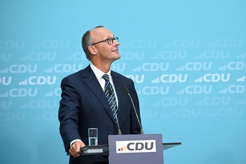 Friedrich Merz schaut bei einer Pressekonferenz noch oben und lächelt