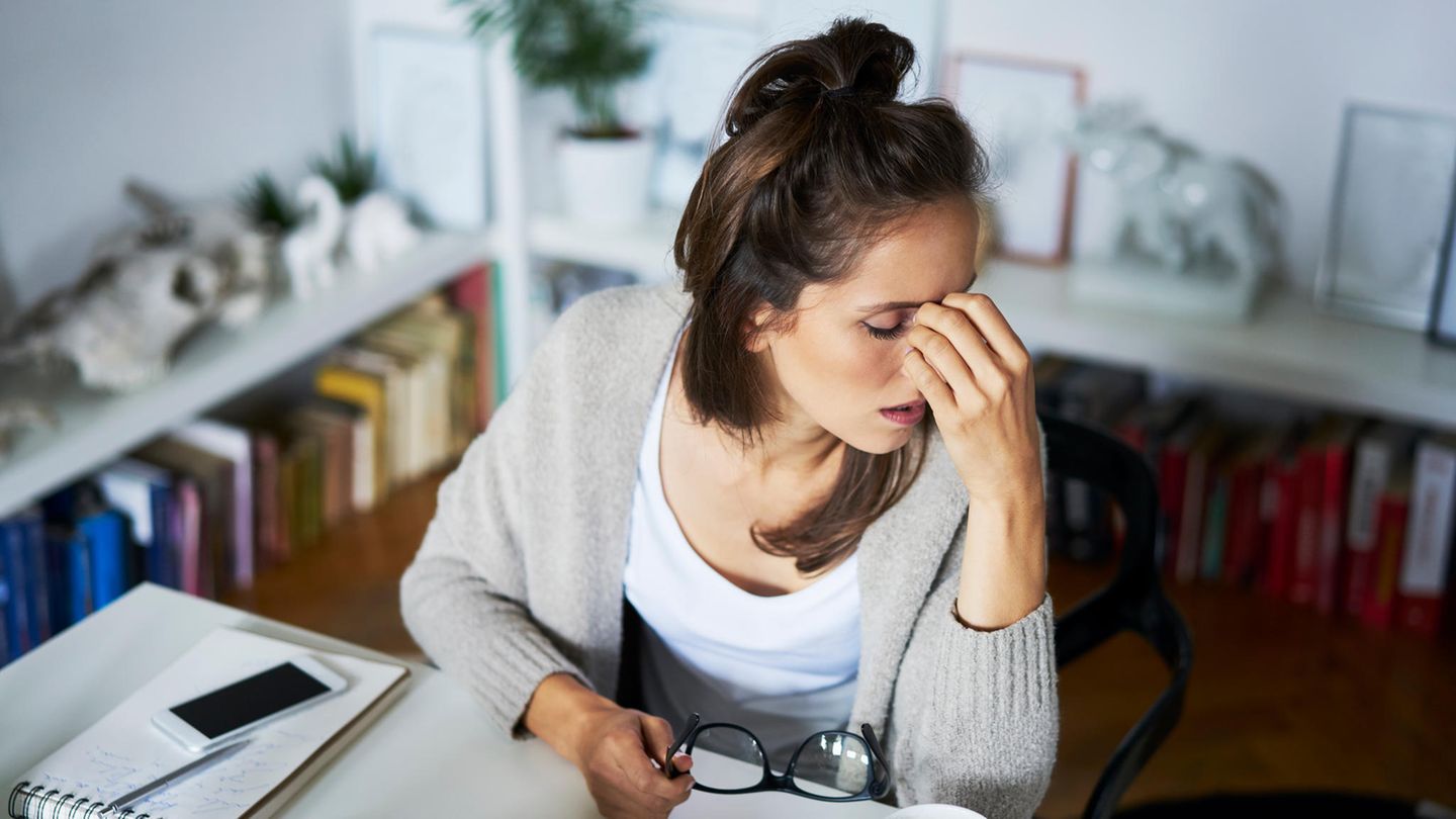 Burnout: Verzweifelte, überarbeitete Frau am Schreibtisch