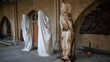 Drei Statuen aus dem Kircheninneren stehen in einer Reihe, an einer davon sind starke Brandspuren zu sehen