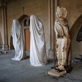 Drei Statuen aus dem Kircheninneren stehen in einer Reihe, an einer davon sind starke Brandspuren zu sehen