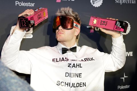 Der Sänger Ski Aggu reckt bei der 1LiveKrone zwei Trophäen in die Luft