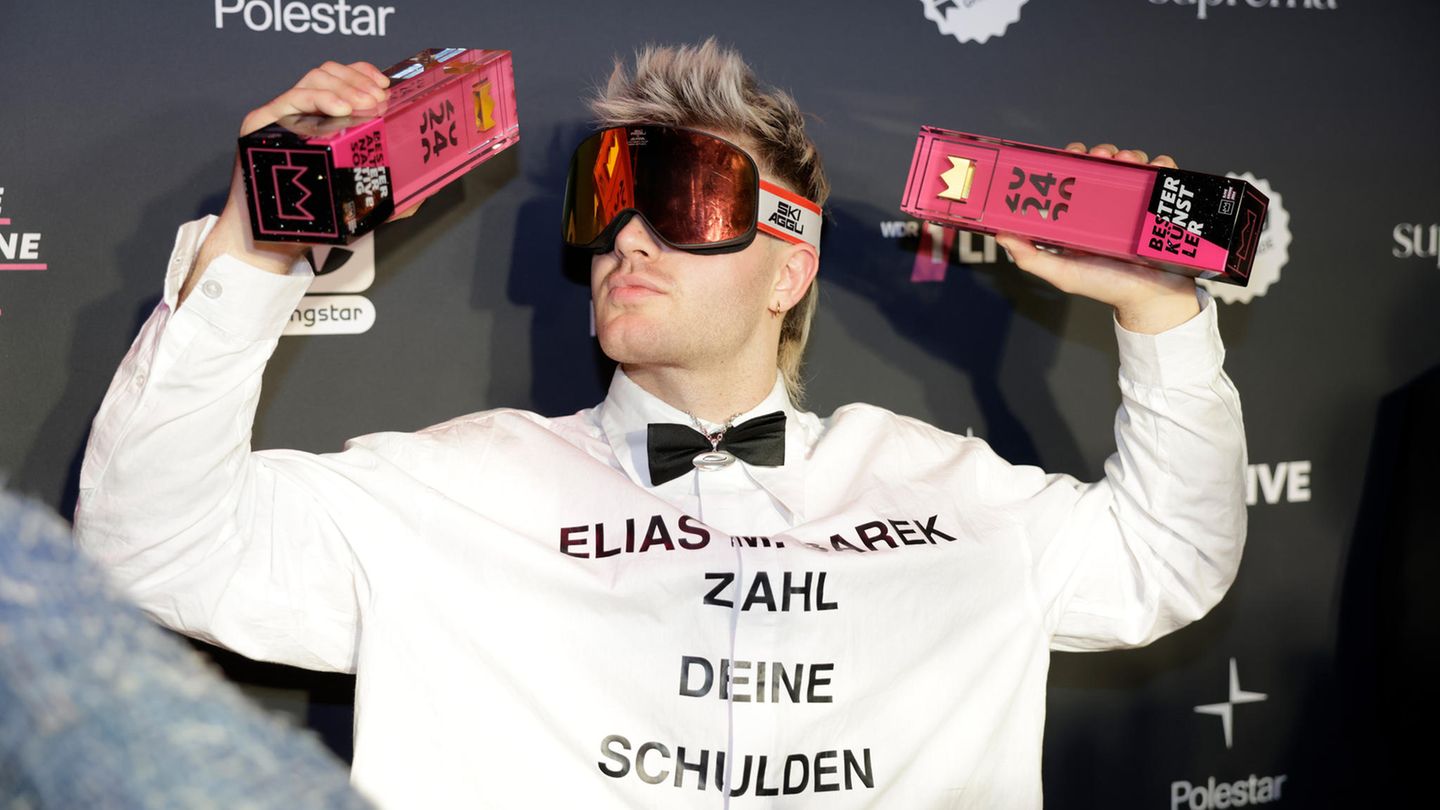 Der Sänger Ski Aggu reckt bei der 1LiveKrone zwei Trophäen in die Luft