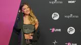 Sängerin Leony posiert vor einer Fotowand