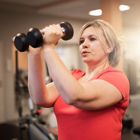 A woman trains her muscles with small dumbbells