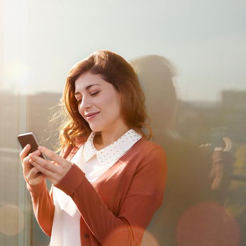Eine Frau nutzt Whatsapp auf ihrem Smartphone