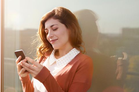 Eine Frau nutzt Whatsapp auf ihrem Smartphone