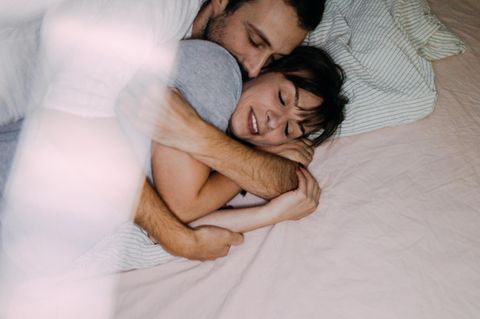 Eltern kuscheln im Bett