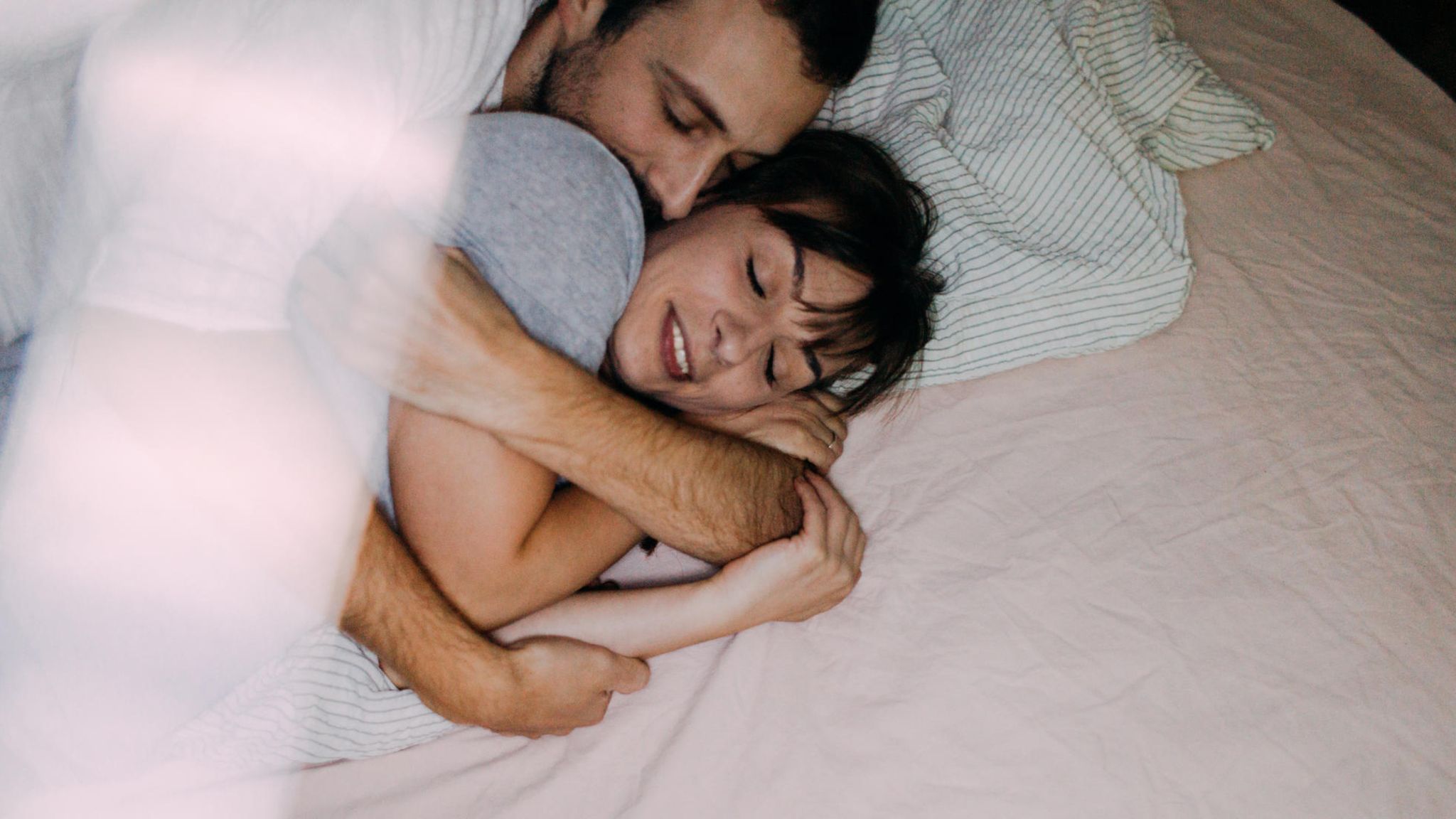 Eltern kuscheln im Bett