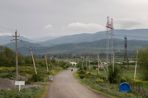 Georgien Ein Mensch läuft eine Straße Richtung des Dorfes Khurvaleti entlang