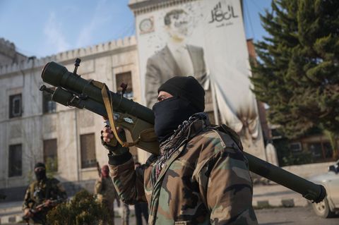 Ein syrischer Oppositionskämpfer vor einem Plakat des Präsidenten Baschar Assad