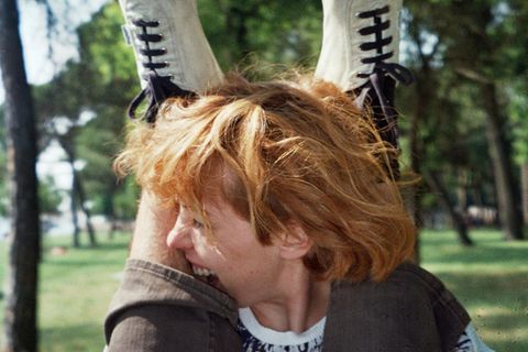 Beißen: Eine rothaarige Frau beißt in einen behaarten Fuß