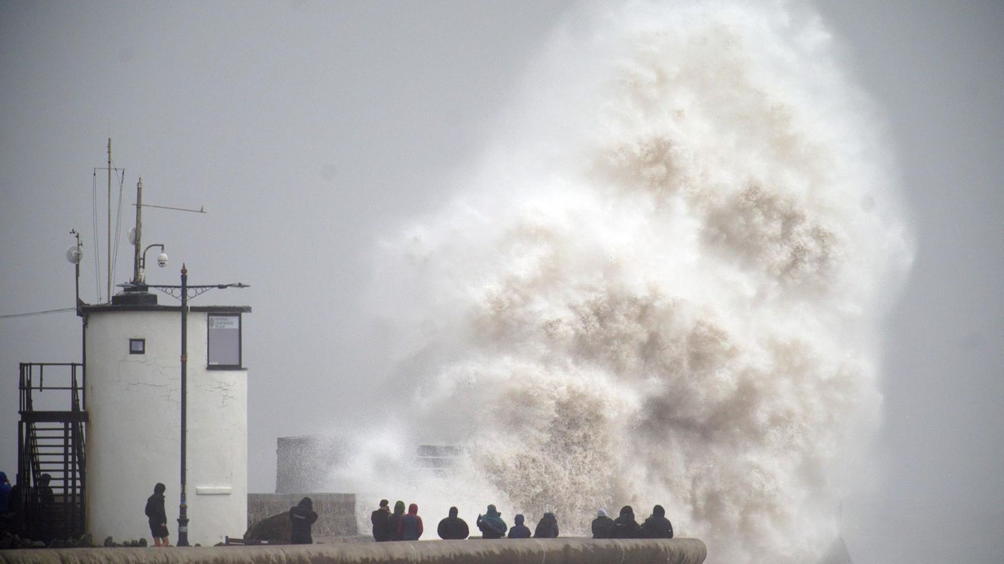 Sturm rollt an: Wellen brechen über die Strandpromenade in Porthcawl in Wales