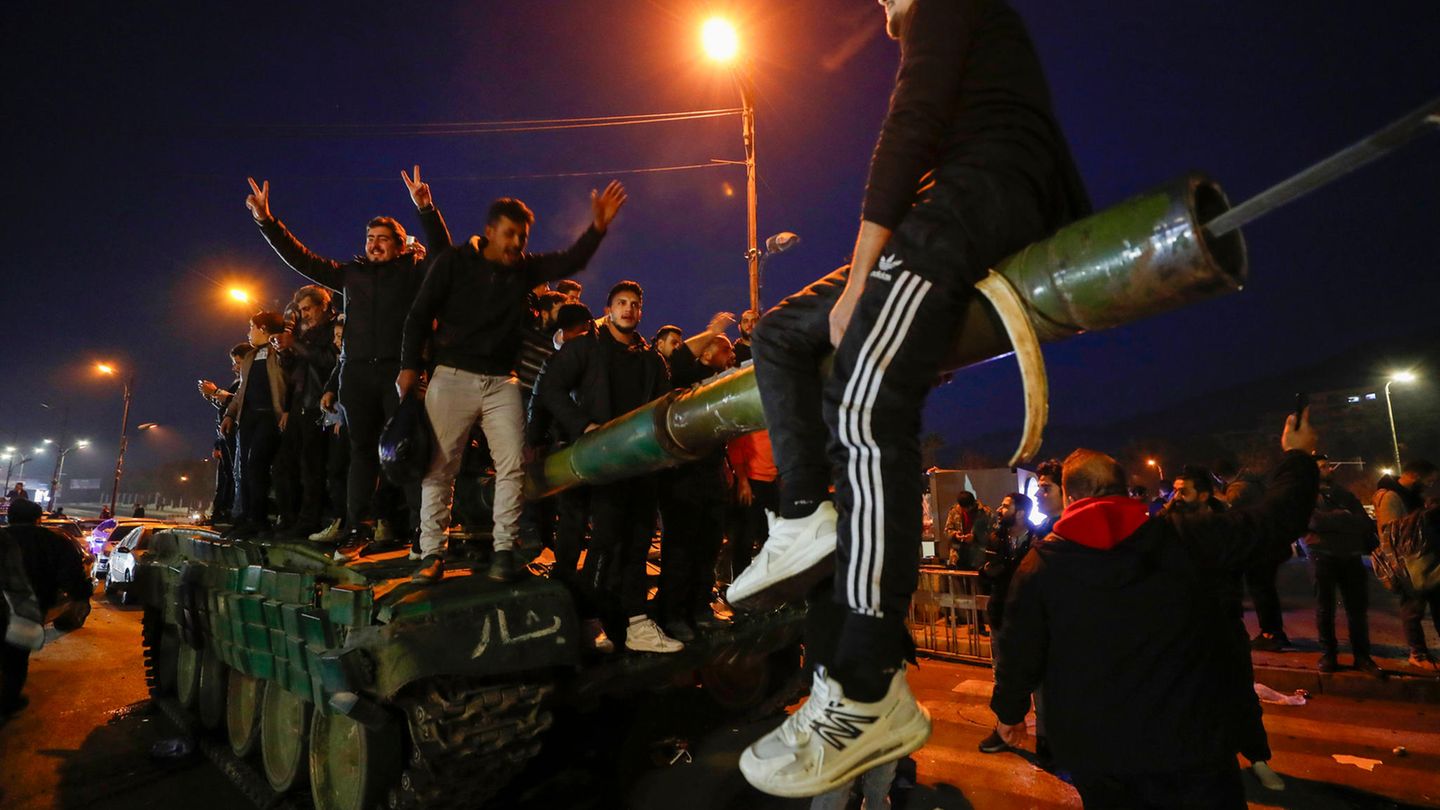 Jubelnde Zivilisten auf einem Panzer: Die Rebellen unter Abu Muhammad al-Dschulani geben sich volksnah