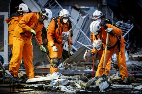 Feuerwehrleute suchen in den Trümmern nach Menschen