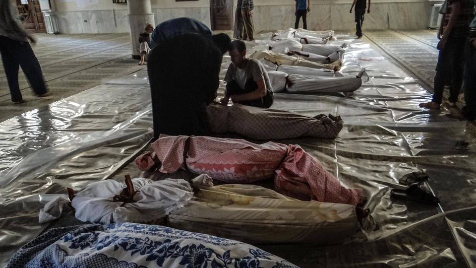 A hall with corpses in colorful cloths.
