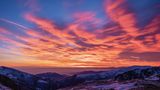 Europas heilige Berge: Schneebedeckte Gipfel mit feuerrotem Sonnenuntergang