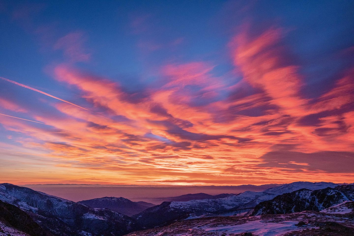Europas heilige Berge: Schneebedeckte Gipfel mit feuerrotem Sonnenuntergang