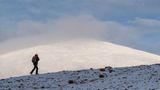 Europas heilige Berge: Wanderer beim Aufstieg auf einen schneebedeckten Gipfel