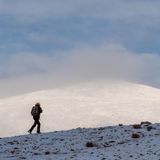 Europas heilige Berge: Wanderer beim Aufstieg auf einen schneebedeckten Gipfel