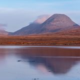 Europas heilige Berge: Drei spitz aufragende Gipfel in einer grasbedeckten Ebene