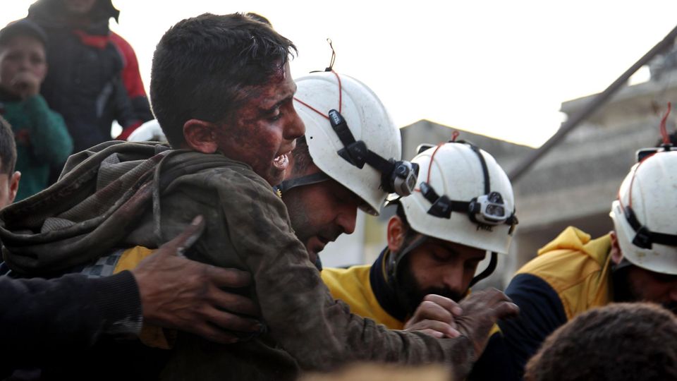 White Helmets members rescue a child after a rocket attack in Idlib in 2020
