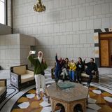 Eine Gruppe von Menschen macht ein Familienfoto, während sie auf einer Couch in einem Saal des Präsidentenpalastes sitzen