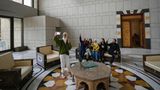 Eine Gruppe von Menschen macht ein Familienfoto, während sie auf einer Couch in einem Saal des Präsidentenpalastes sitzen