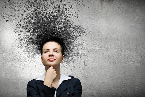 Was die Psyche aufbaut: junge Businessfrau lächelt trotz dunkler Gedankenwolke um ihren Kopf