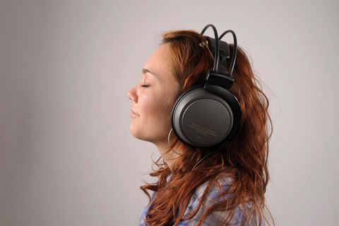 Junge Frau mit roten Haaren mit Kopfhörern