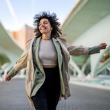 Eine Frau läuft lachend auf der Straße