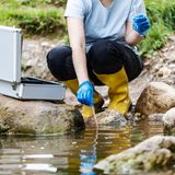 Eine Wissenschaftlerin nimmt eine Wasserprobe