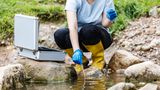 Eine Wissenschaftlerin nimmt eine Wasserprobe