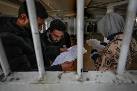 Menschen inspizieren Dokumente, die sie in Syriens berüchtigtem Saidnaja-Militärgefängnis gefunden haben