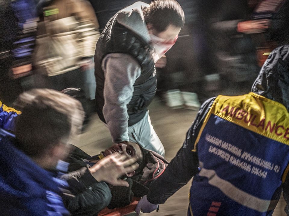 Protestanten helfen einen Verletzten zu transportieren