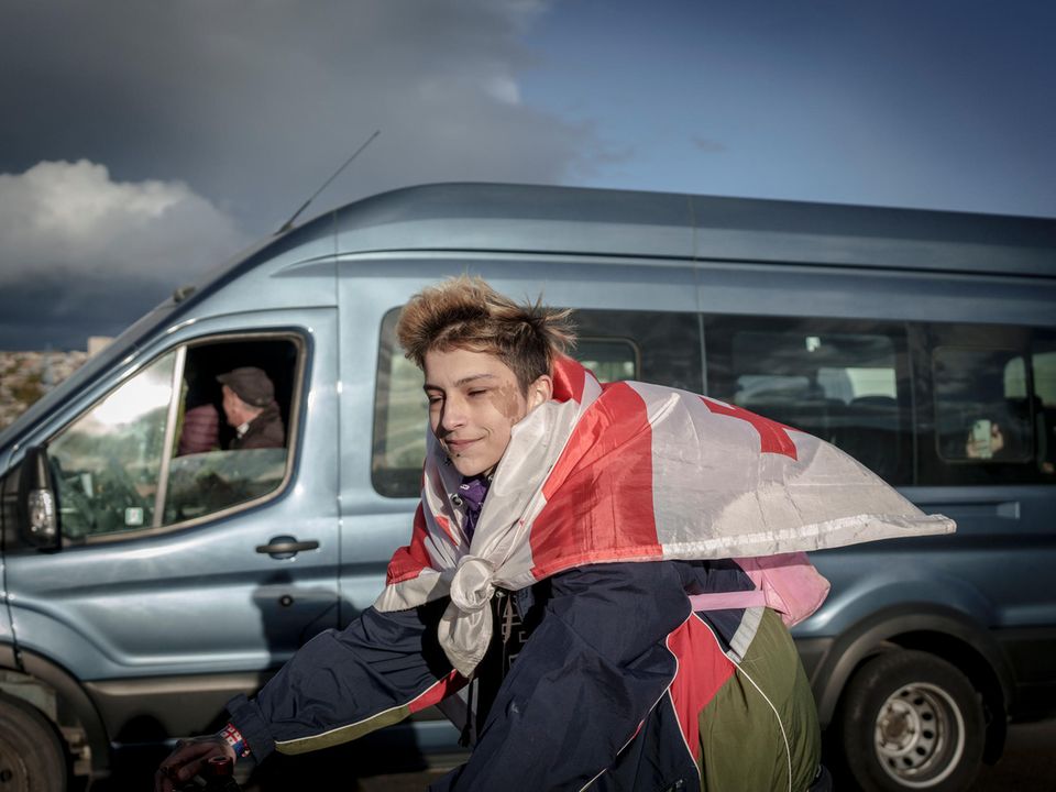 Jugendlicher mit Georgien-Flagge um die Schultern gebunden