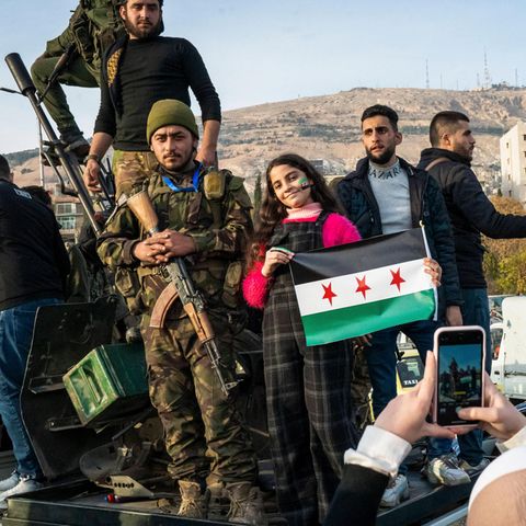 Menschen in Syrien jubeln mit HTS-Kämpfern