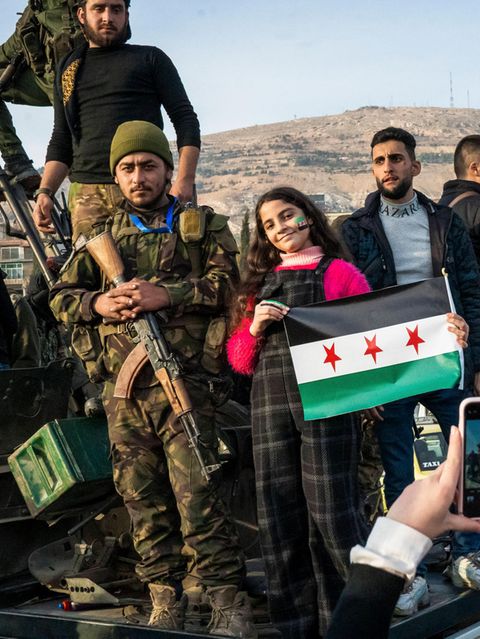 Menschen in Syrien jubeln mit HTS-Kämpfern