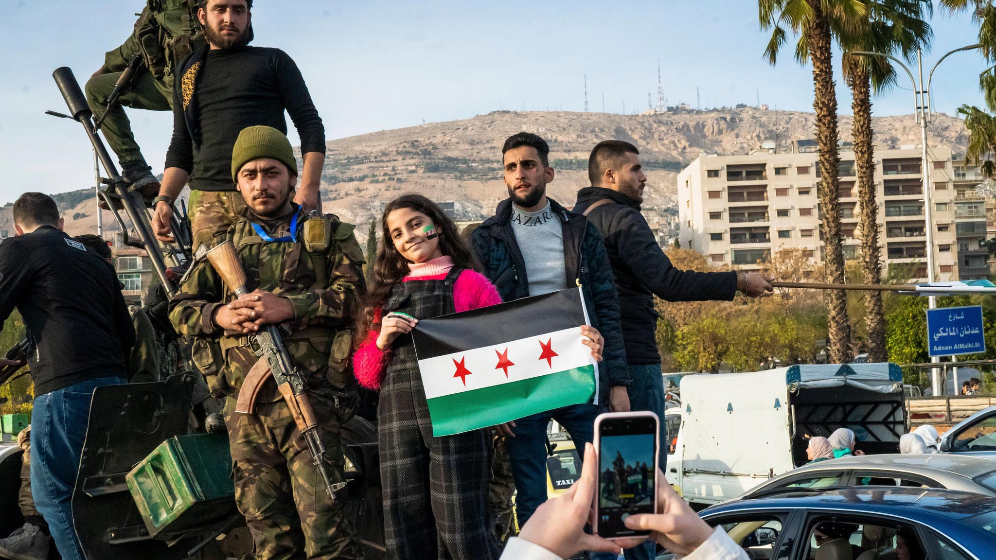 Menschen in Syrien jubeln mit HTS-Kämpfern
