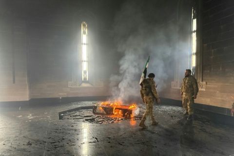 Milizionäre neben dem brennenden Sarg von Hafis al-Assad