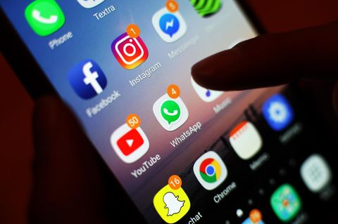 Ein Finger tippt auf einem Smartphone-Bildschirm mit Apps von Meta wie Facebook, Instagram oder Whatsapp