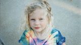 Taylor Swift als kleines Kind mit bloinden Locken in einem Batik-T-Shirt