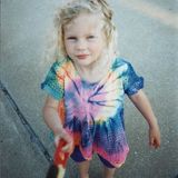 Taylor Swift als kleines Kind mit bloinden Locken in einem Batik-T-Shirt