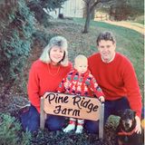 Taylor Swift als Baby mit ihren Eltern. Mutter Andrea und Vater Scott tragen beide rote Pullover