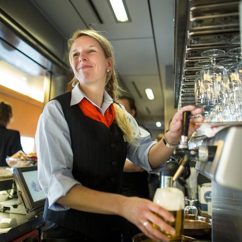 Deutsche Bahn: Eine Bistro-Mitarbeiterin zapft ein Bier im Bordbistro