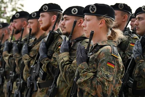 Soldaten und Soldatinnen der Bundeswehr stehen mit ihrem Gewehr. Überwachen sie bald einen Waffenstillstand in der Ukraine?