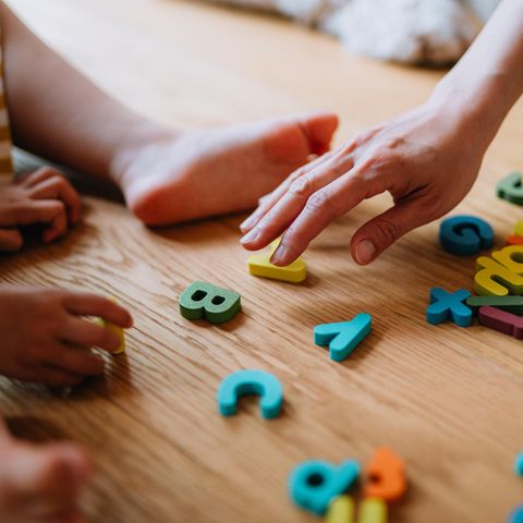 Kita: Ein Kind und seine Erzieherin spielen auf dem Fußboden