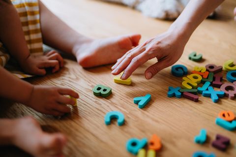 Kita: Ein Kind und seine Erzieherin spielen auf dem Fußboden